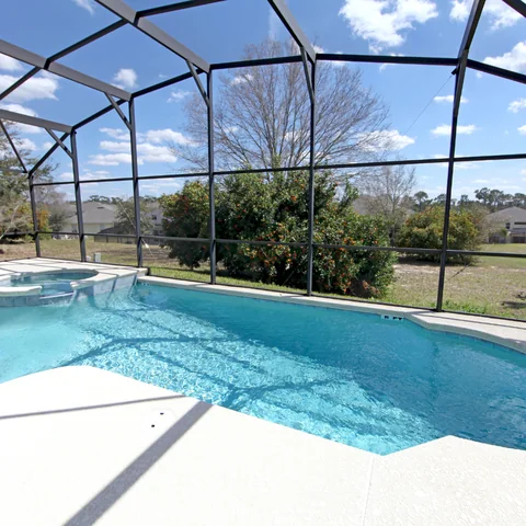 Swimming pool within a screened outdoor enclosure