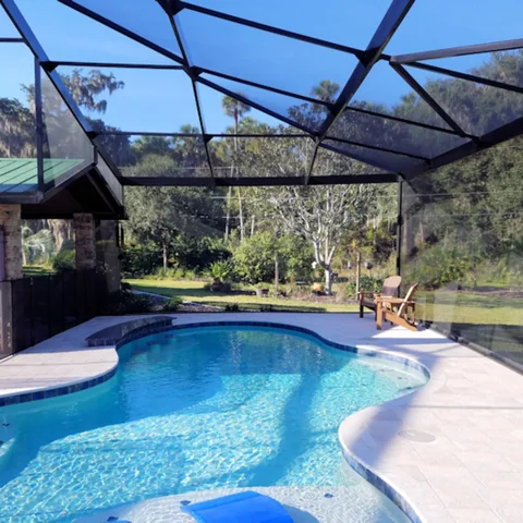 Screen enclosure surrounding a residential swimming pool
